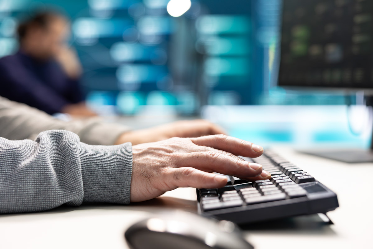 Governmental IT expert monitoring cyber threats on a computer and big screen