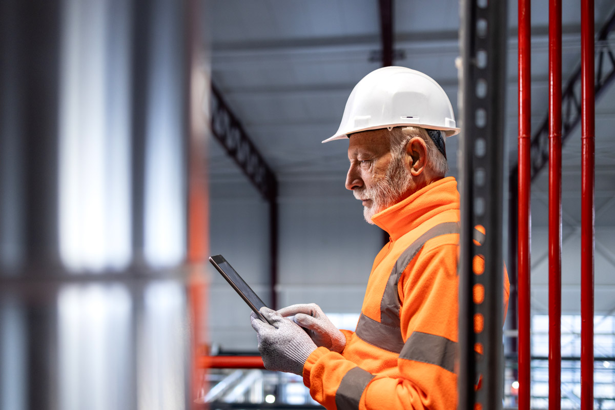 Senior engineer using tablet in industrial facility